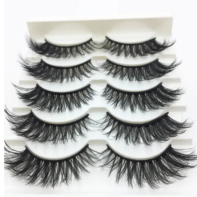 Voluminous 3D mink eyelashes in assorted styles, displayed on a white surface at Skin Deep Beauty&More.